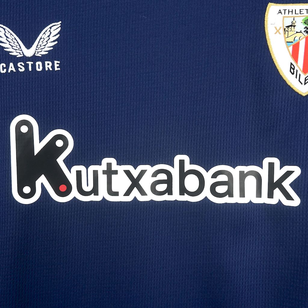 camisa-atlhetic-bilbao-il-2025-26-torcedor-masculina-camiseta-champions-league-lancamento-europeu-segunda-away-oficial-kutxabank-castore-azul-escuro-azul-claro-gola-azul-manga-azul